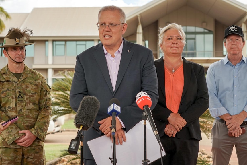 Prime Minister Scott Morrison stands at a press conference with a Defence personal, and Senator Sam Mcmahon 