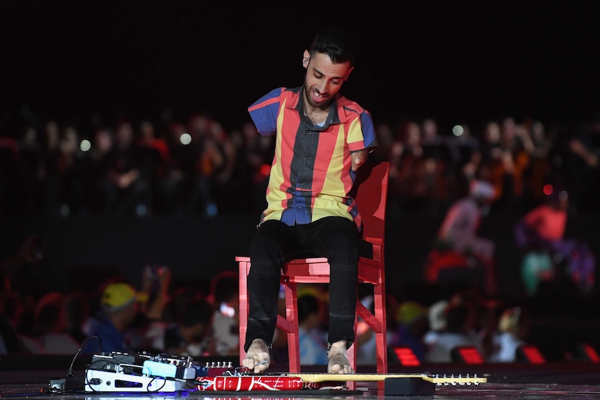 Festive atmosphere ... Musician Johnatha Bastos plays electric guitar with his feet during the closing ceremony