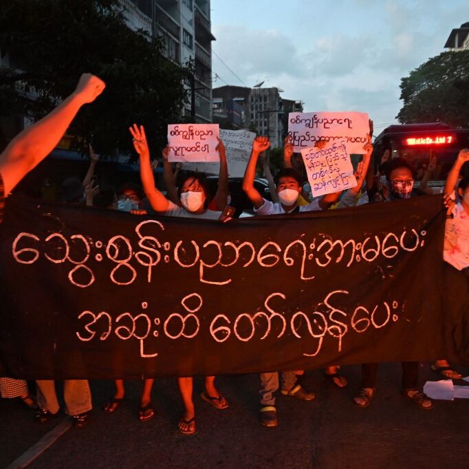 Protesters, with signs and with raised fists in take part in a demonstration against the military coup in Yangon on Nov10.