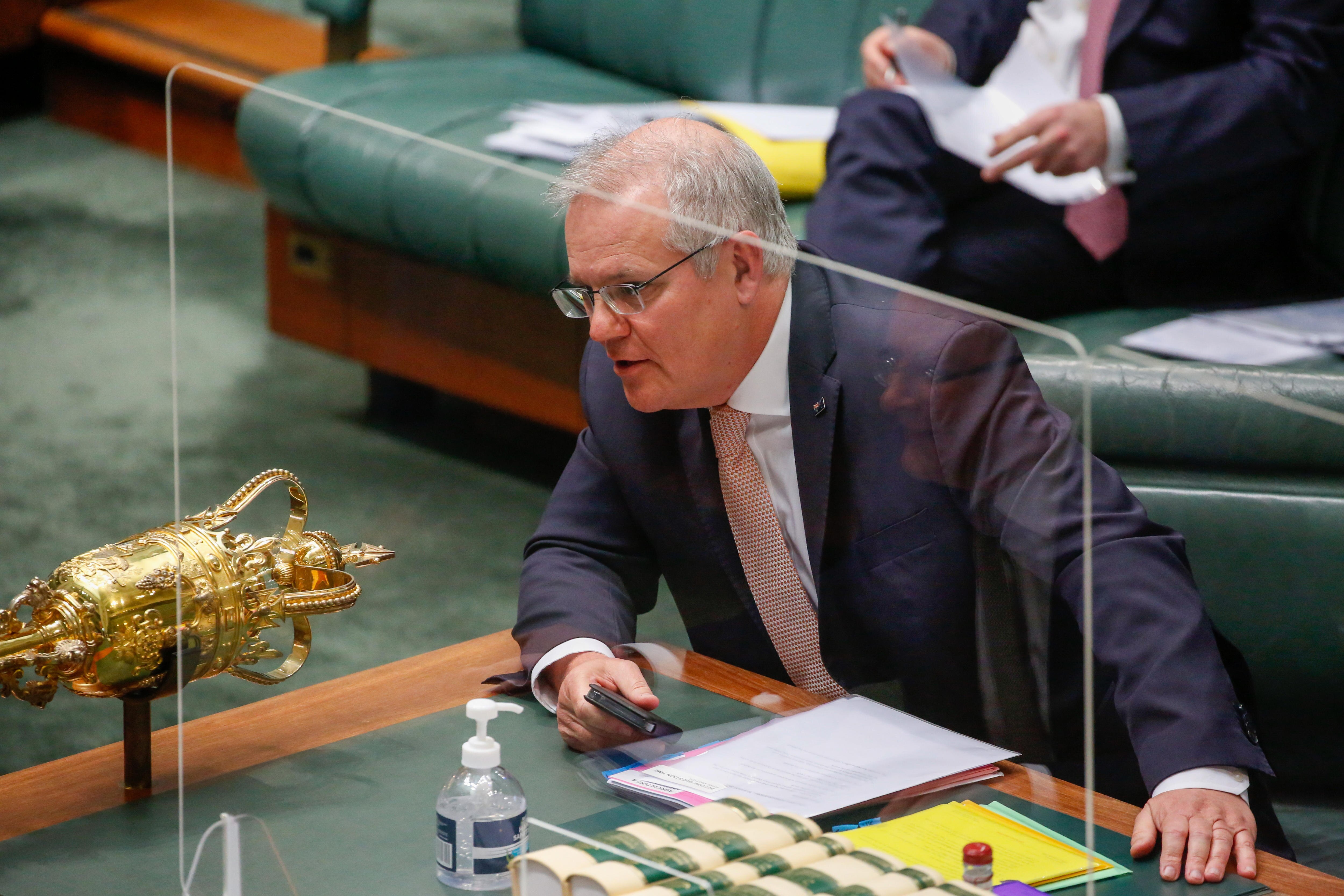 The Prime Minister sits behind a glass partition in the House of Representatives chamber.