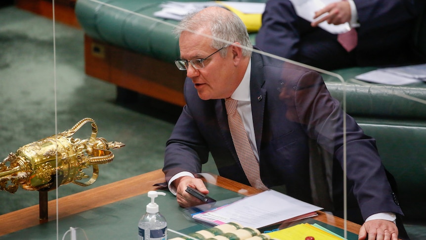 The Prime Minister sits behind a glass partition in the House of Representatives chamber.