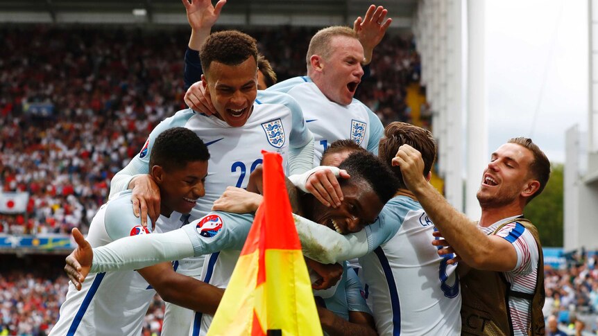 England mobs Daniel Sturridge after winner against Wales
