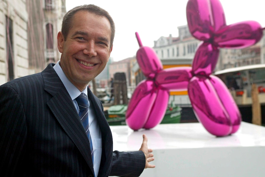 Artist Jeff Koons poses with his sculpture Balloon Dog (Magenta).