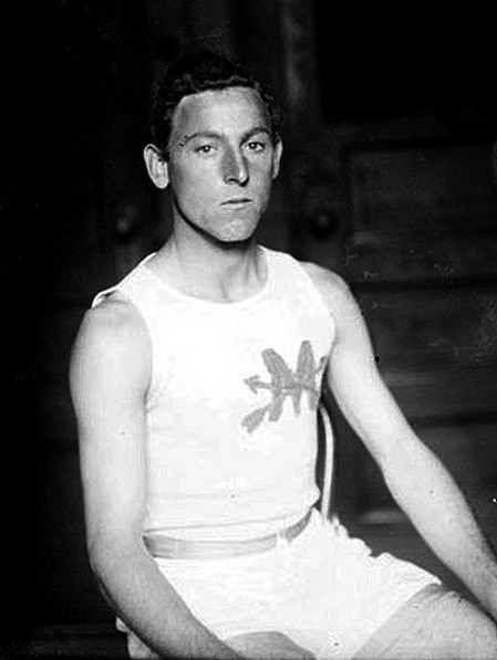 A black and white photo of a young man in white running clothes