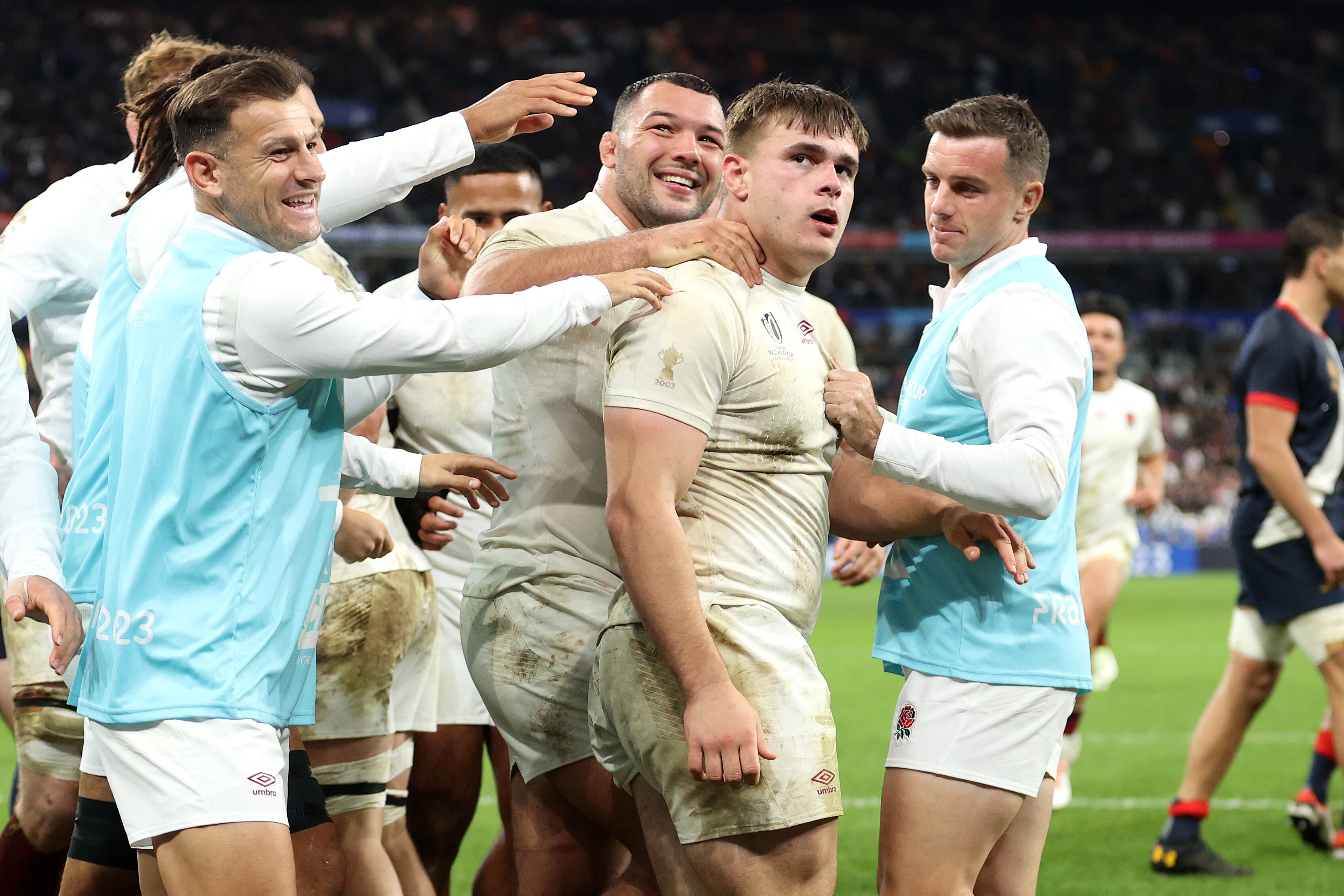 England players, including some substitutes, gather around Theo Dan
