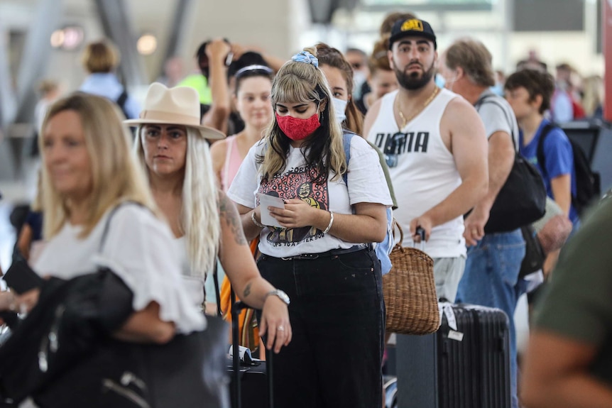 long queues at Sydney Airport with people waiting for checkout