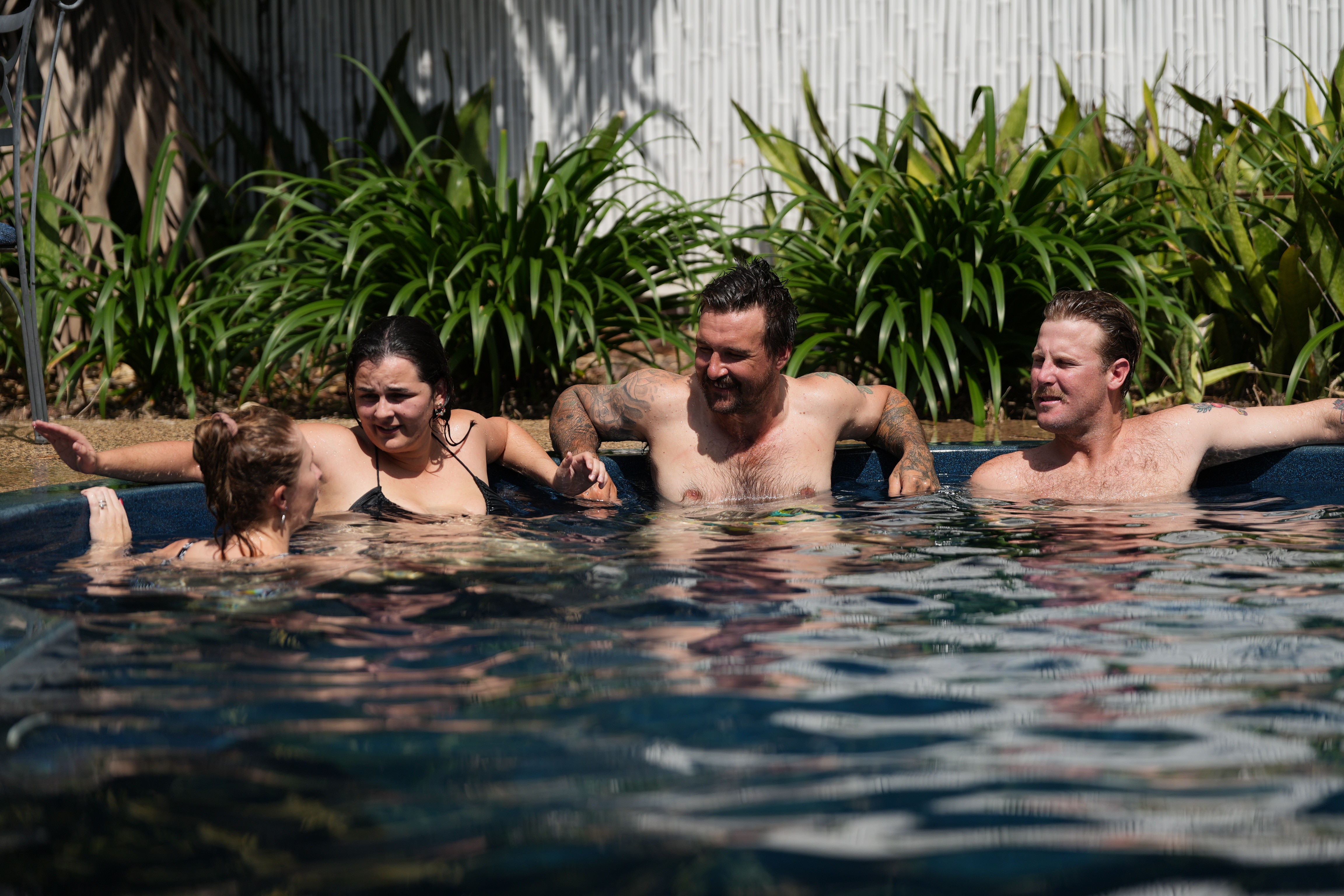 Um grupo de amigos relaxando na piscina do quintal.