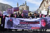Hundreds walk the streets of Kabul wearing masks and holding signs