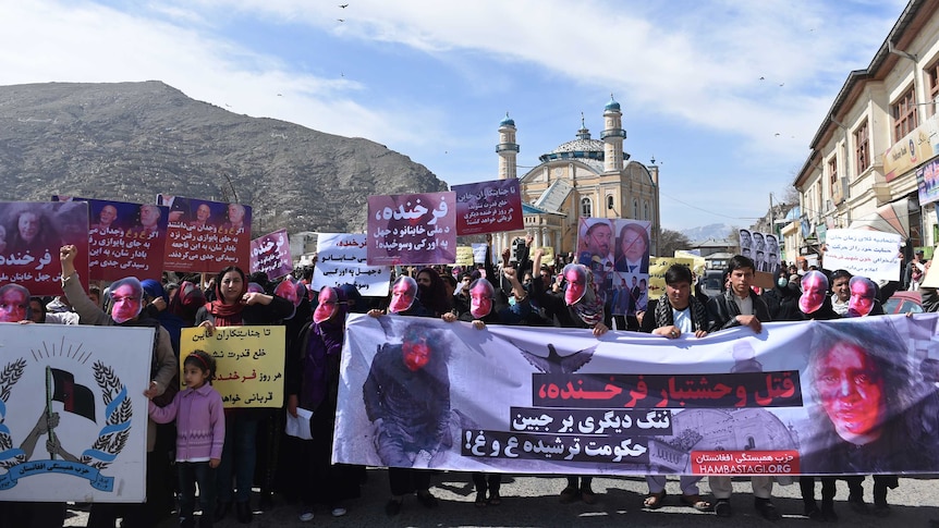 Hundreds walk the streets of Kabul wearing masks and holding signs
