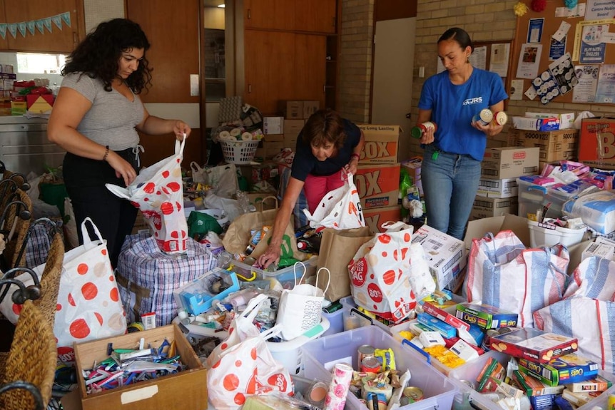 Three women pack boxes