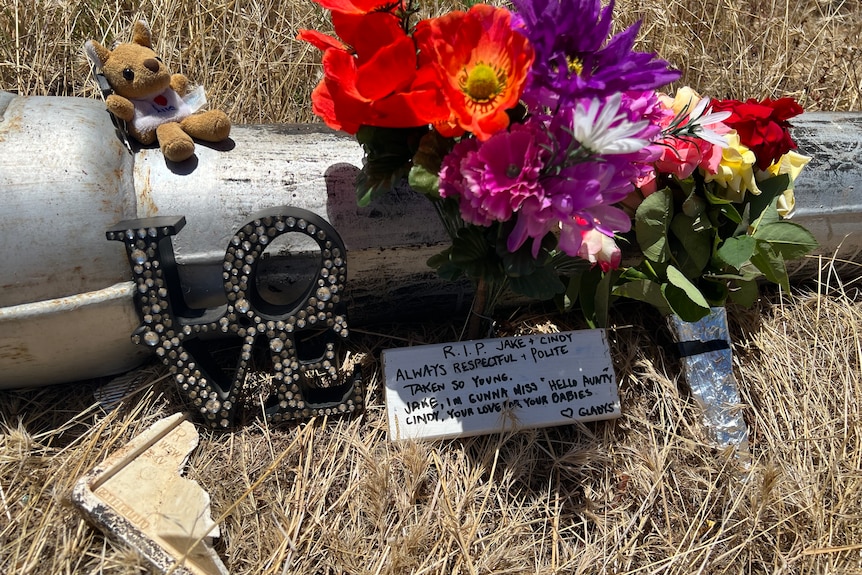 Flowers, a teddy bear and a note left in a roadside tribute to a couple who died in a road crash