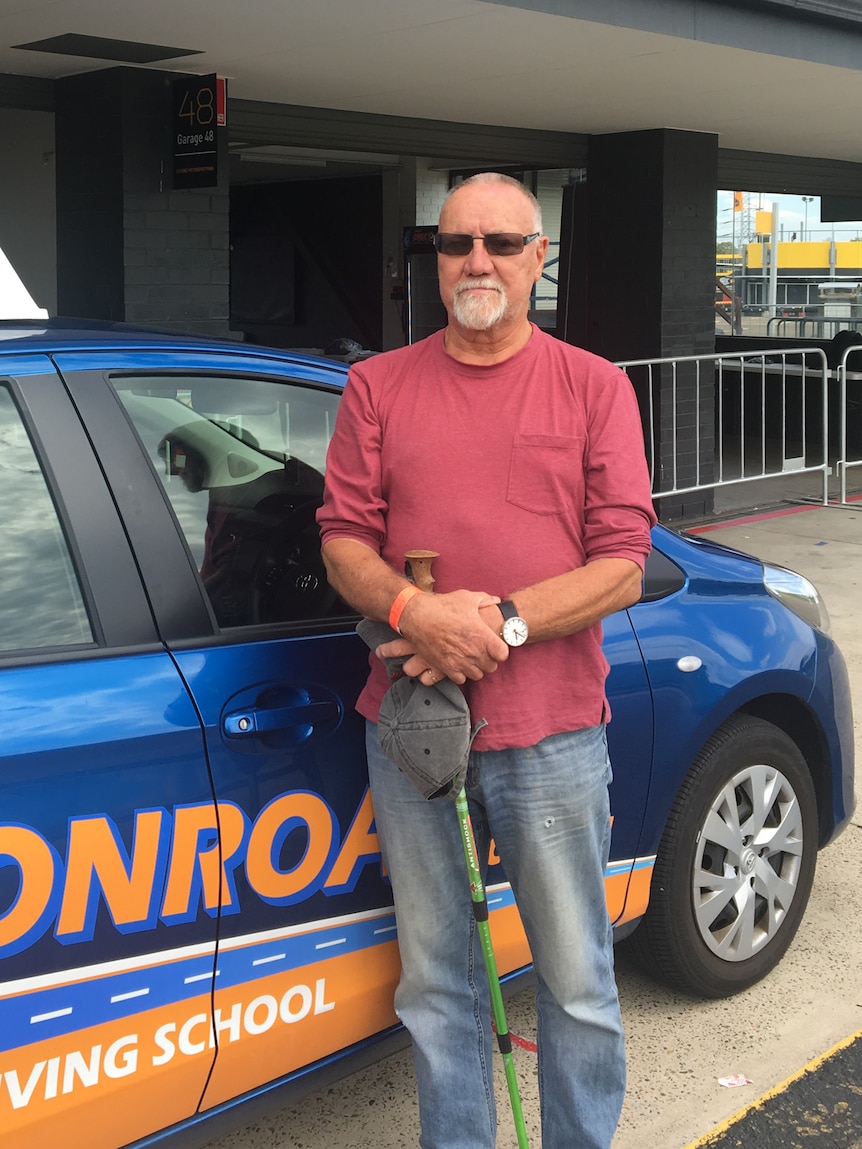 Driving participant Tony Partridge in front of car.