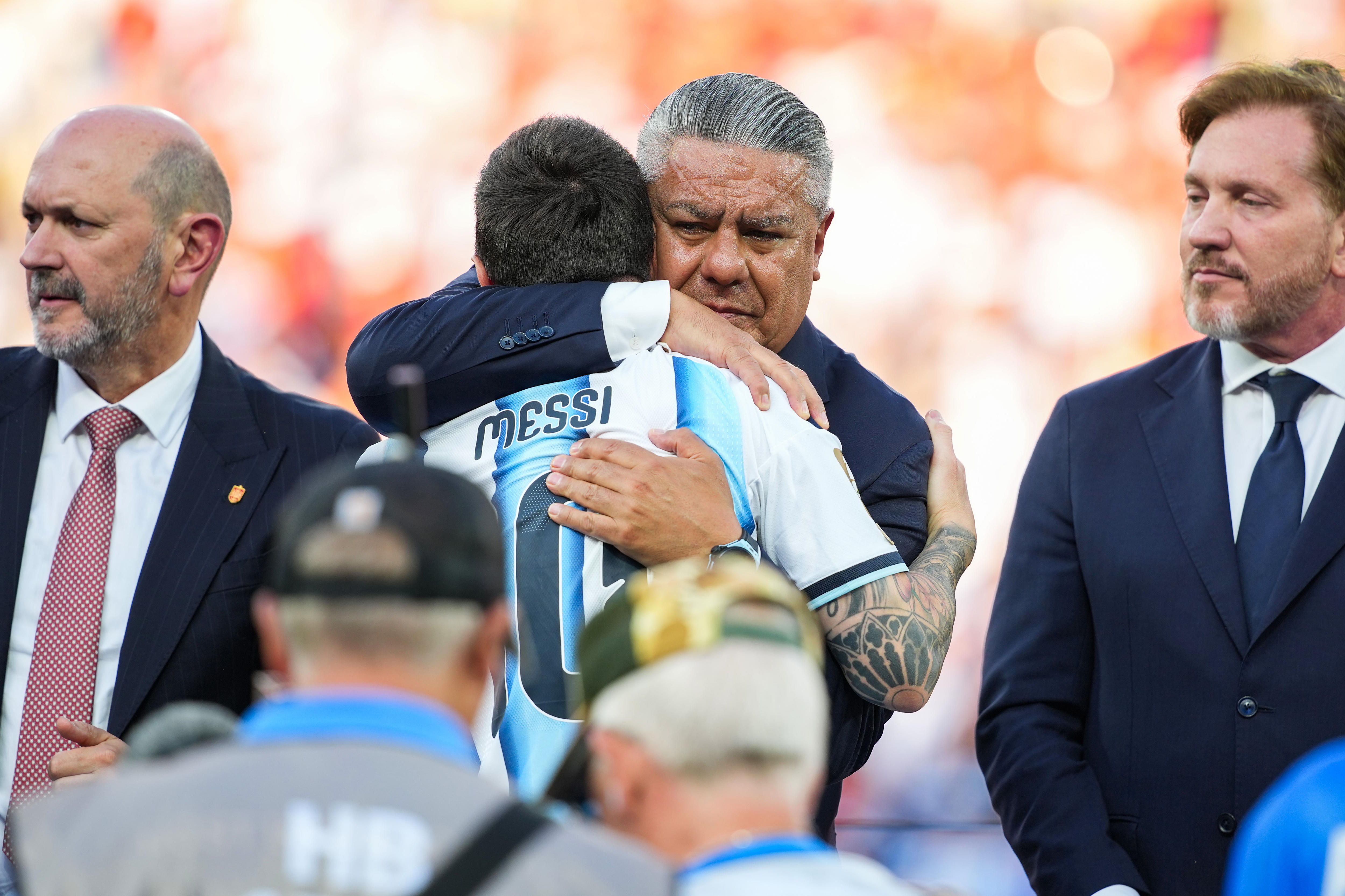 Claudio Tapia hugs Lionel Messi