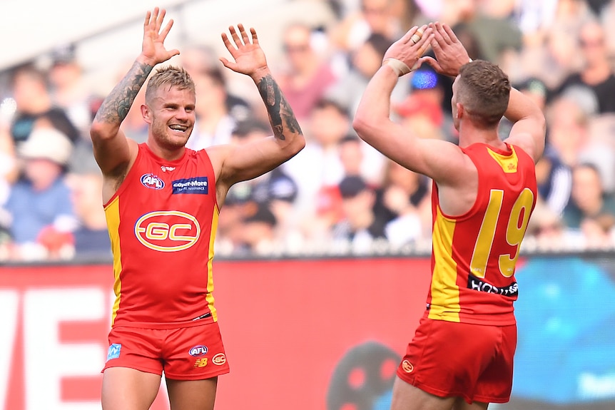 Brandon Ellis of the Gold Coast Suns moves to high five a teammate during an AFL win over Collingwood.