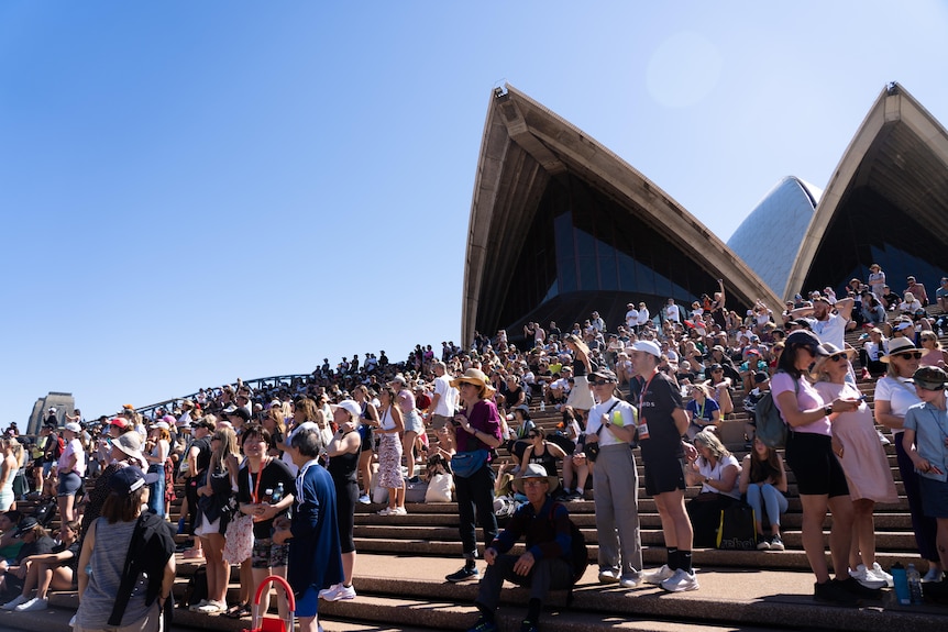people stand on the steps of the opera house