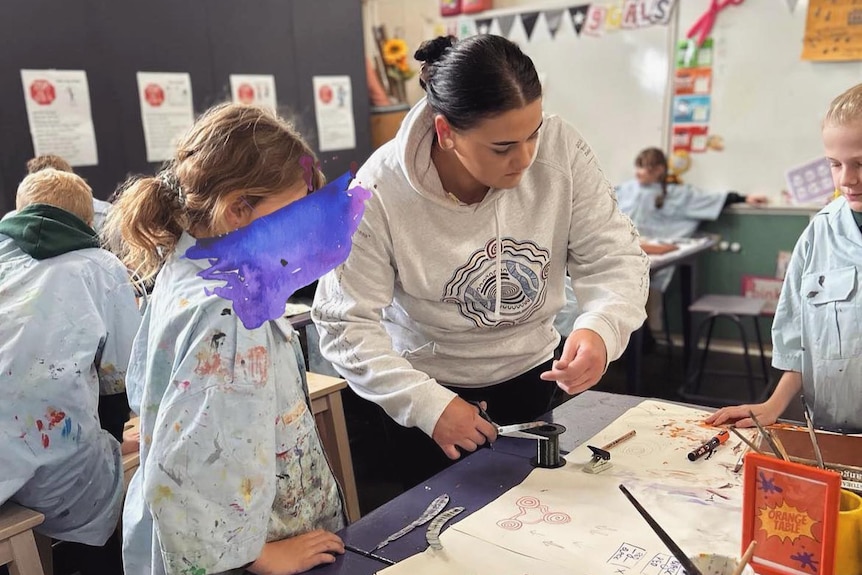 Montana McStay in an art class with students