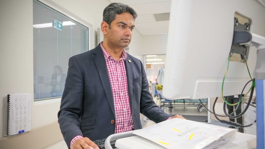 Associate Professor Naren Gunja looking at a computer at Sydney's Westmead Hospital.