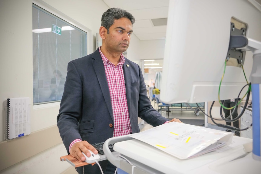 Associate Professor Naren Gunja looking at a computer at Sydney's Westmead Hospital.