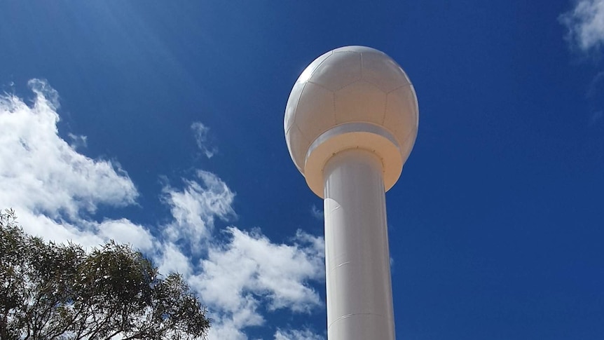 a tall white pole with a round ball on top.