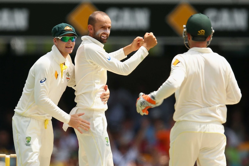 Nathan Lyon and Steve Smith celebrate the wicket of Shikhar Dhawan on day four of the second Test between Australia and India at the Gabba