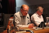 Broken Hill Mayor, Wincen Cuy, sits at a table during a council meeting