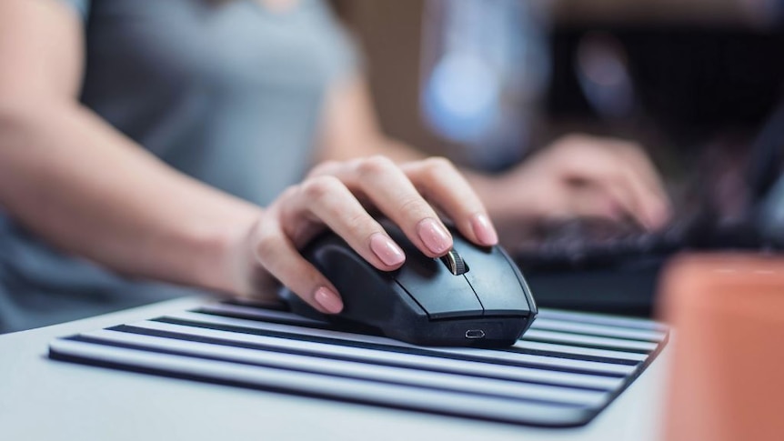 A close up of a female hand on a computer mouse.