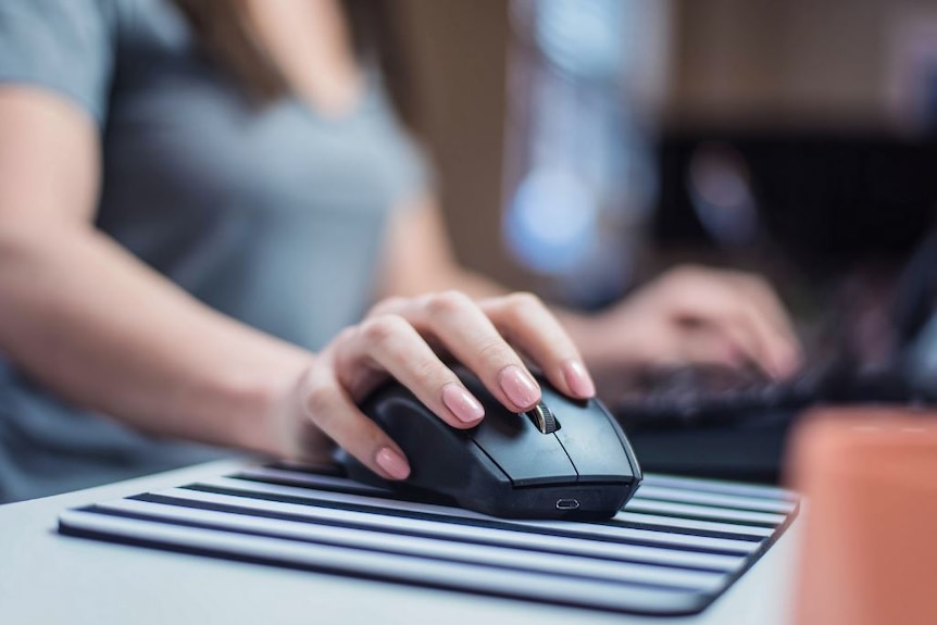 A close up of a female hand on a computer mouse.