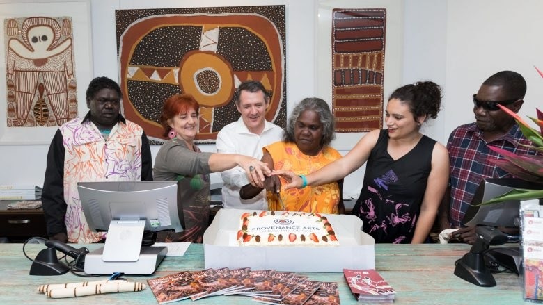 The group gathers around a cake