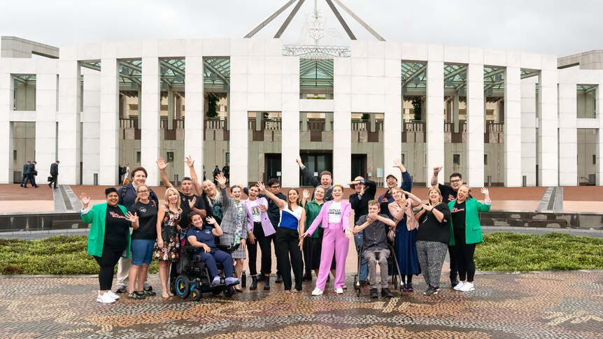 A group of young people stand outside of Parliament House