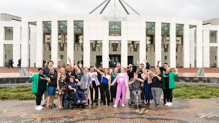 A group of young people stand outside of Parliament House