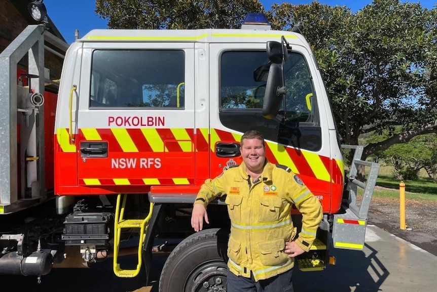 a man stands in RFS uniform in front of a fire truck