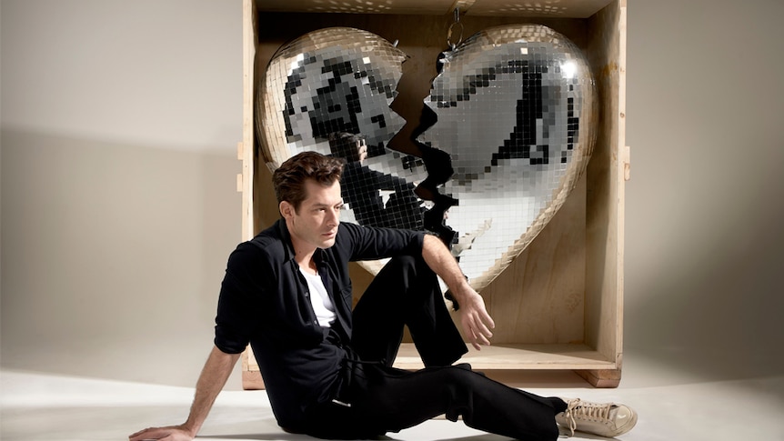 A 2019 press shot of Mark Ronson and a giant crate holding a broken heart disco ball