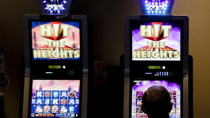 A man sits in front of a poker machine