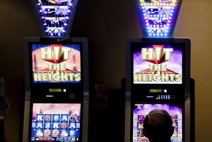 A man sits in front of a poker machine