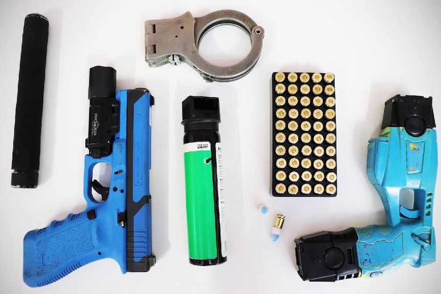 Photo of a training versions of what police carry including a baton, a pistol, handcuffs, capsicum spray, bullets and a taser.