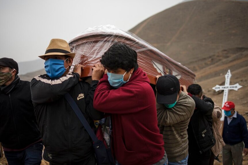 Relatives wearing masks to protect from the spread of the new coronavirus carry the coffin
