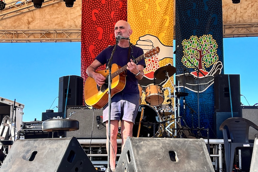 Paul Kelly stands on stage at Freedom Day Festival. 