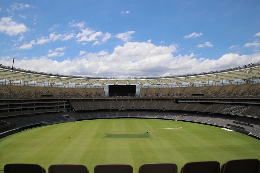 A wide view of Perth Stadium's interior, showing an oval, giant screen and three tiers of seating.