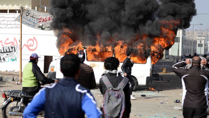 Smoke billows from a burning minibus belonging to a satellite channel after it was set on fire by Egyptian protesters.