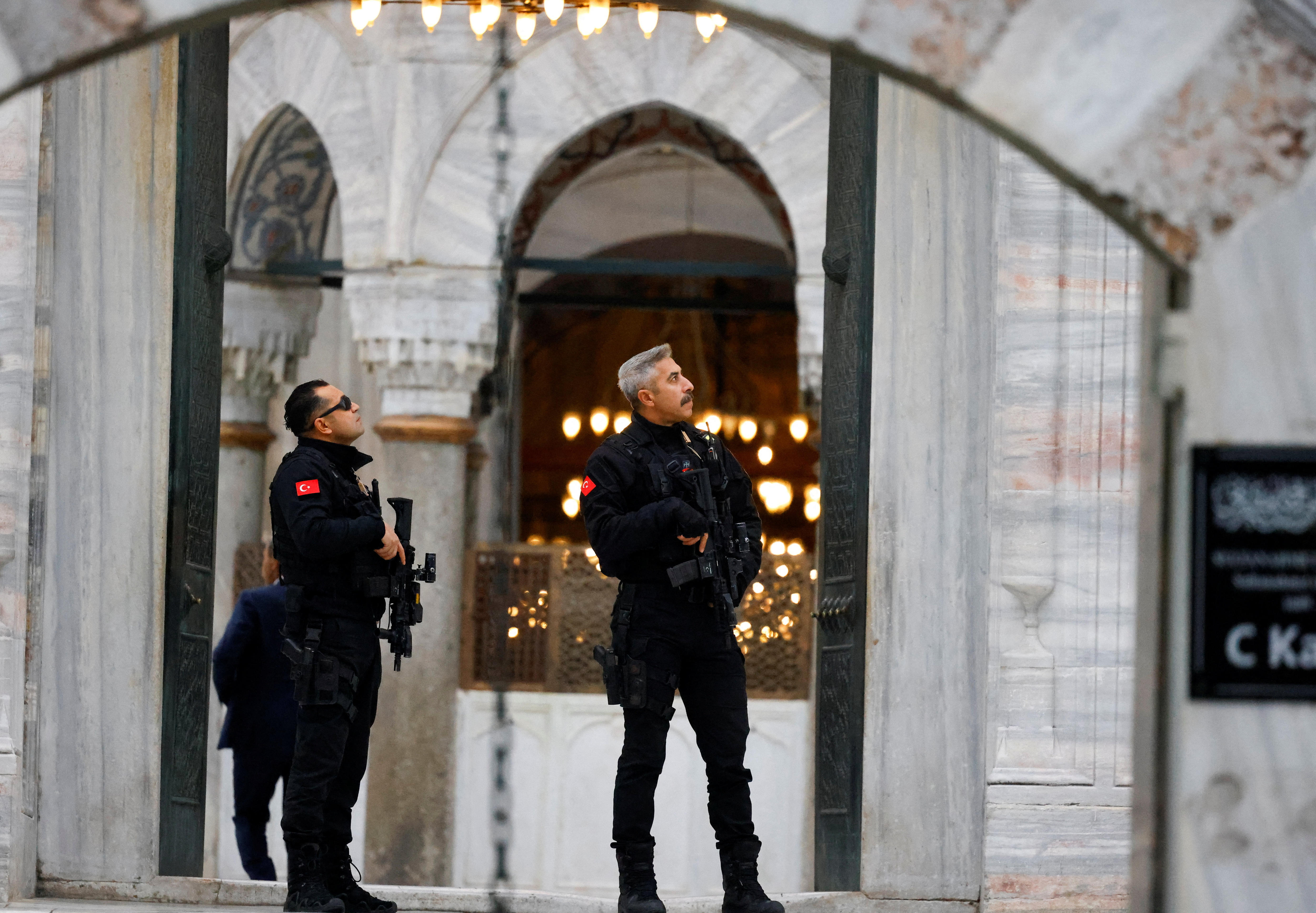 Dos fuerzas de seguridad armadas frente a una mezquita.