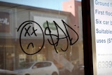 Graffiti saying 'sad' sprayed on a wall of an empty shop in Armadale