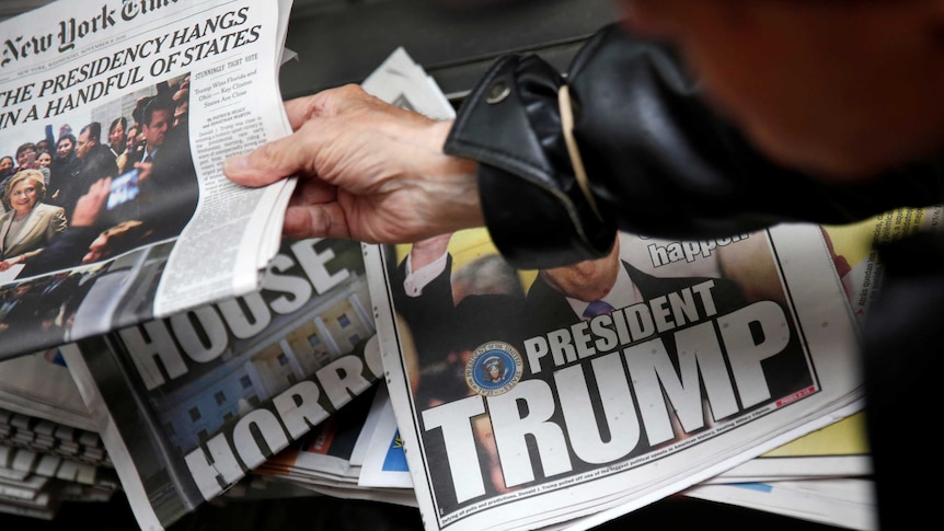 Piles of newspapers with front pages about Donald Trump's election win.