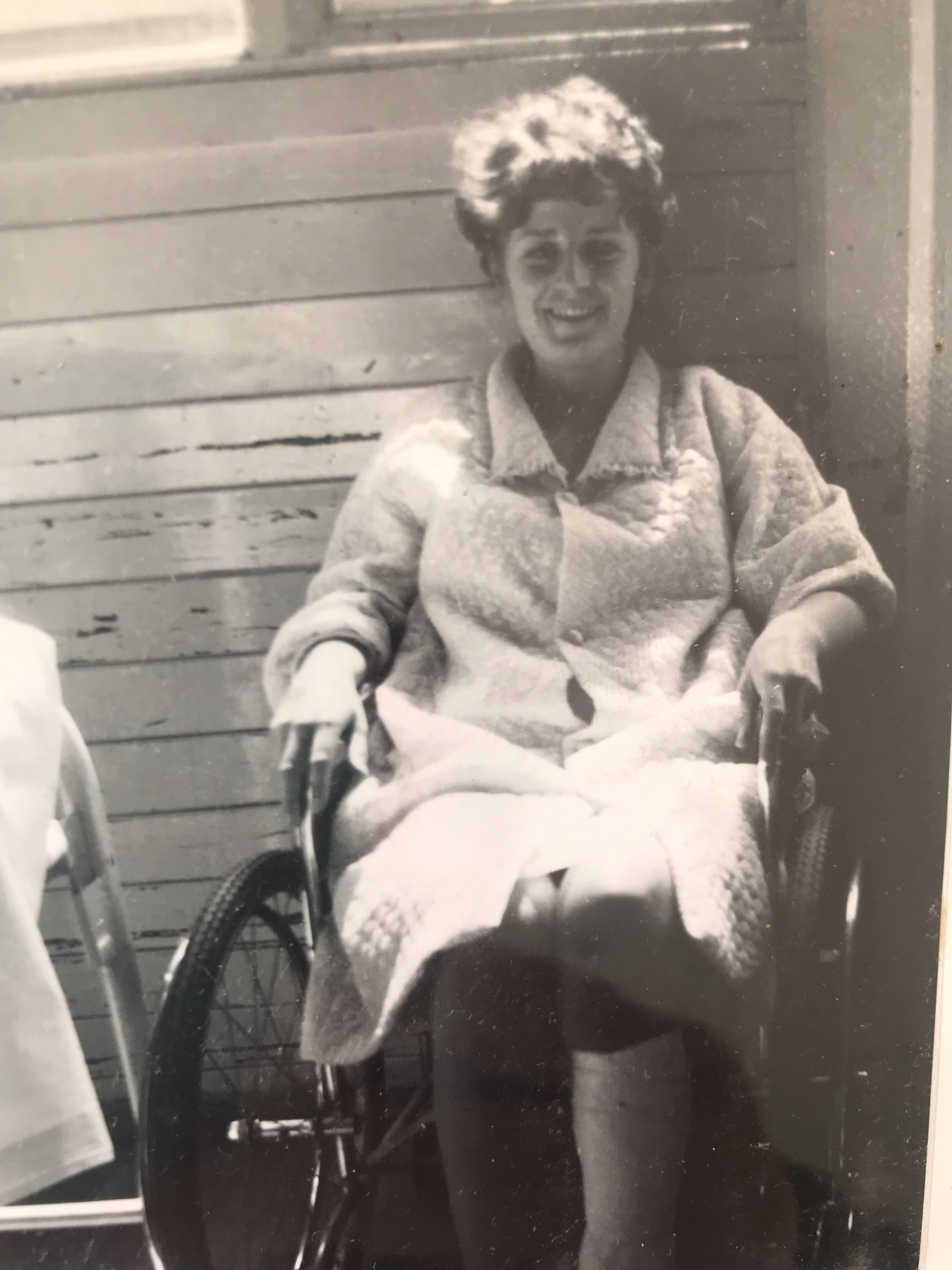 A black and white photo of a young woman in a wheelchair