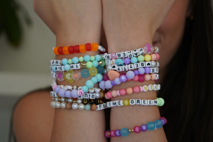 Colourful friendship bracelets on a woman's wrist.