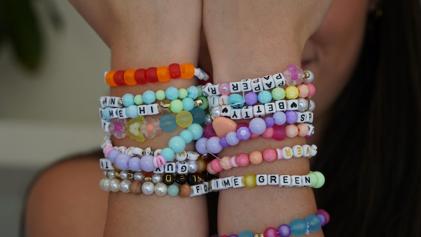 Colourful friendship bracelets on a woman's wrist.