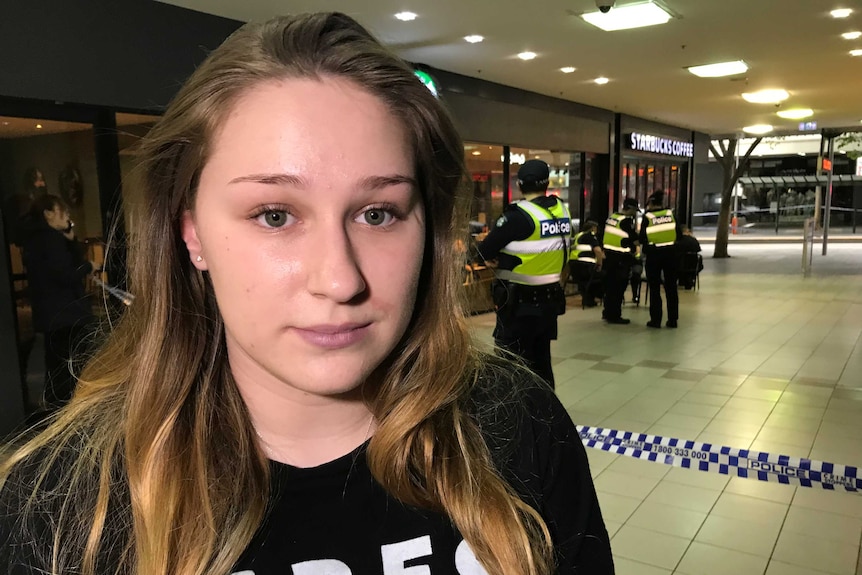 Ella Campbell stands in front of police tape.