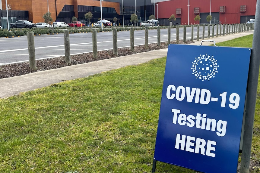 Blue sign alerting drivers to test for COVID-19