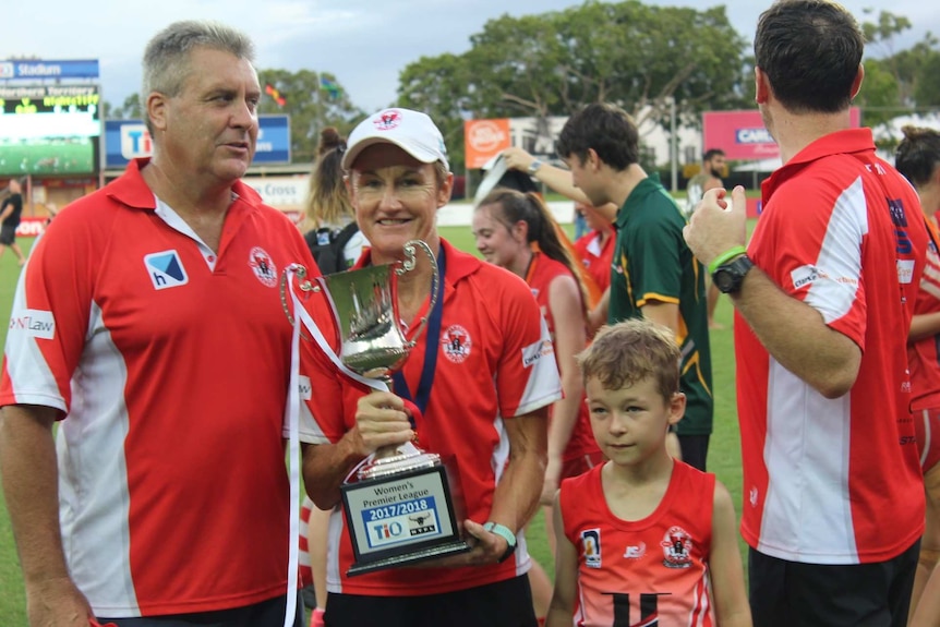 Waratah's coach Colleen Gwynne stands with the premiership trophy in Darwin.