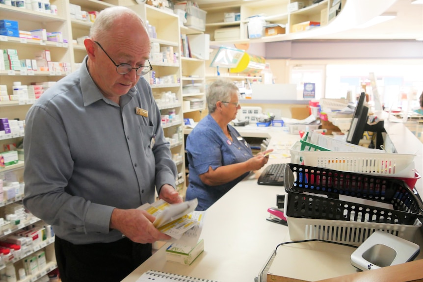 a man sorts through pharmacy scripts