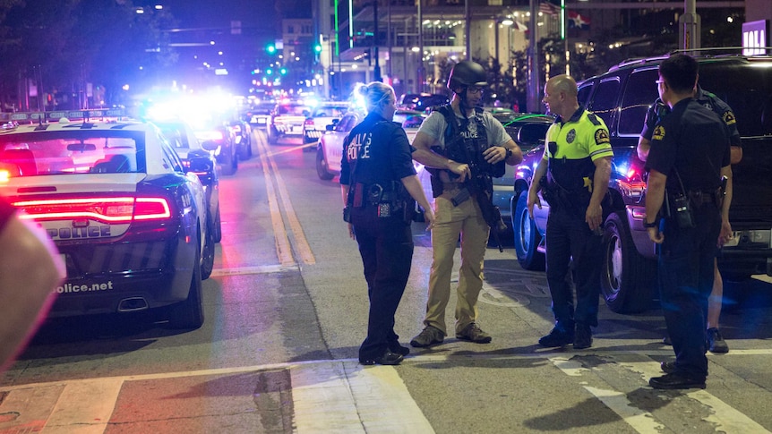 A group of police officers stand together talking.